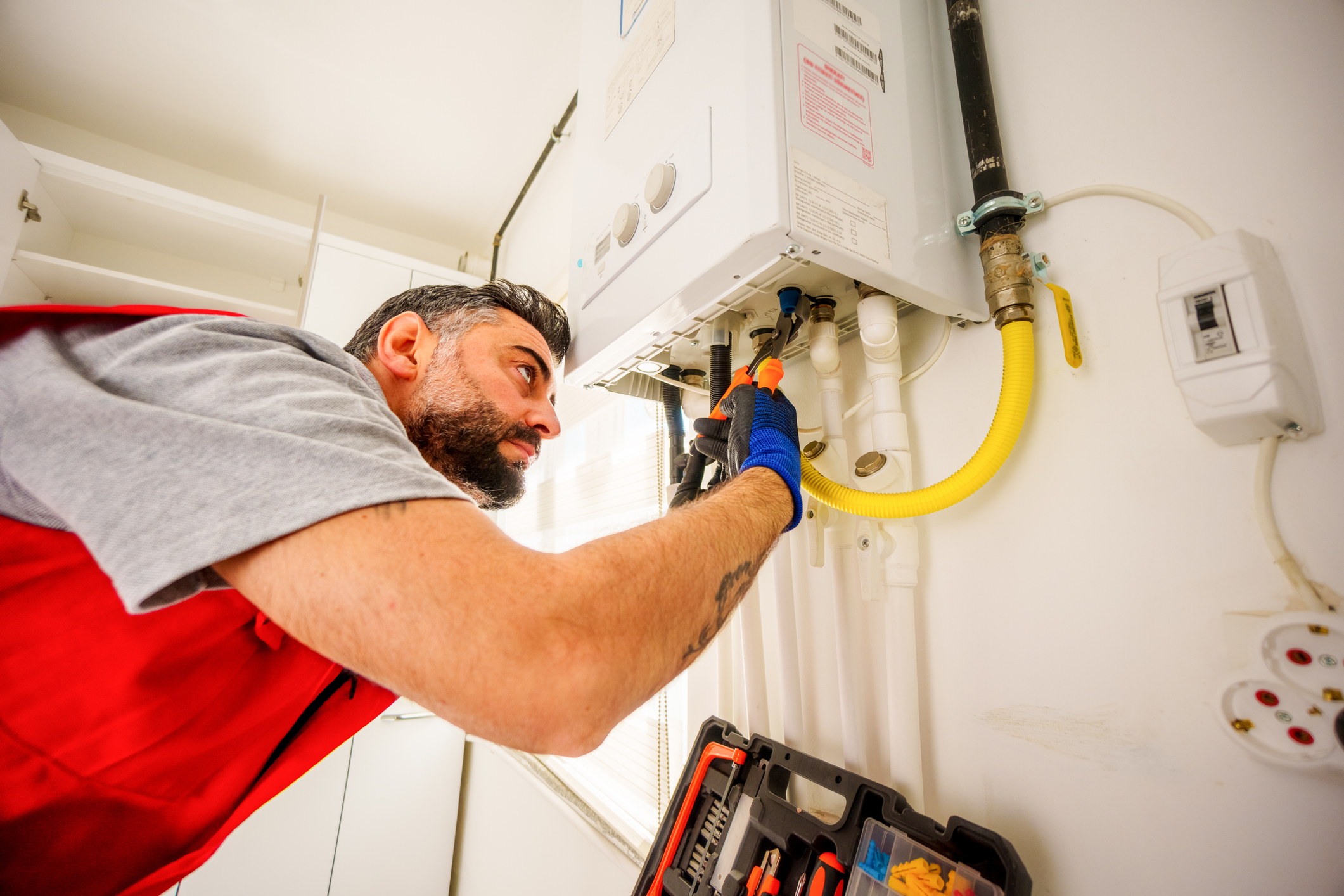 Plumber fixing gas boiler with tools