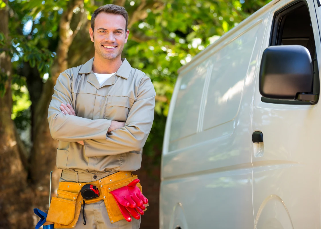 Man in work uniform near vehicle