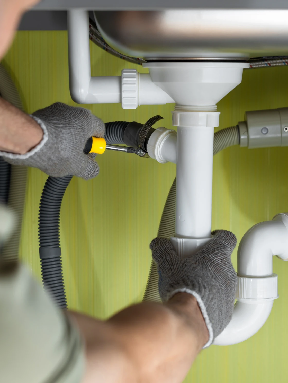 Plumber fixing kitchen sink pipes
